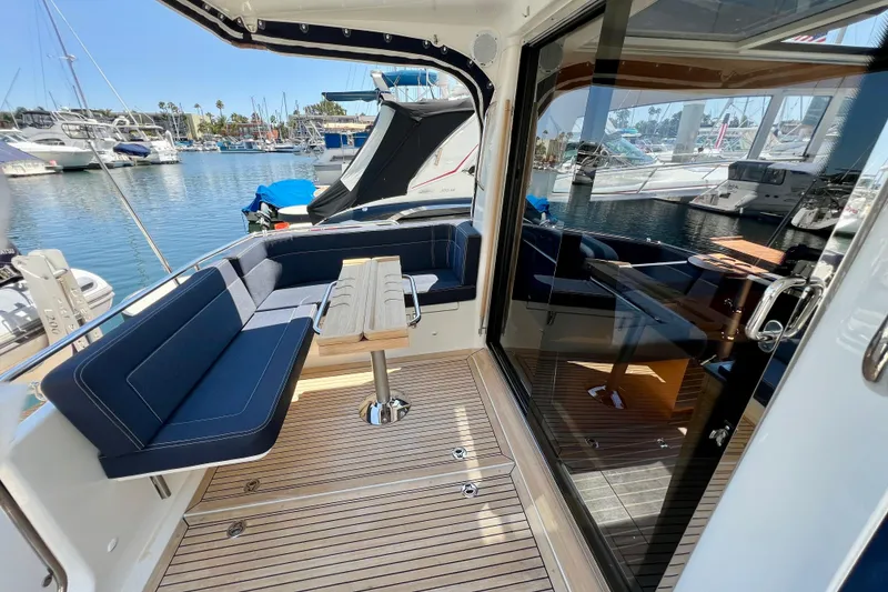 Slide: The Image of 2018 Nimbus 365 Coupe yacht interior with seating and table, docked at marina. - 41