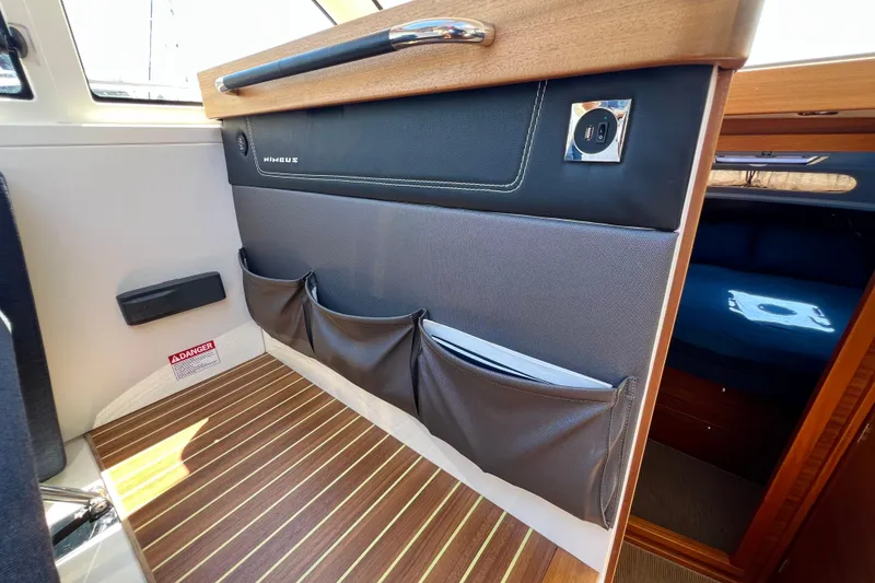 Slide: The Image of Interior of 2018 Nimbus 365 Coupe boat with storage pockets and wood flooring. - 84