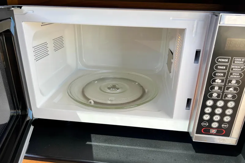 Slide: The Image of Open microwave oven with control panel and glass turntable inside. - 113