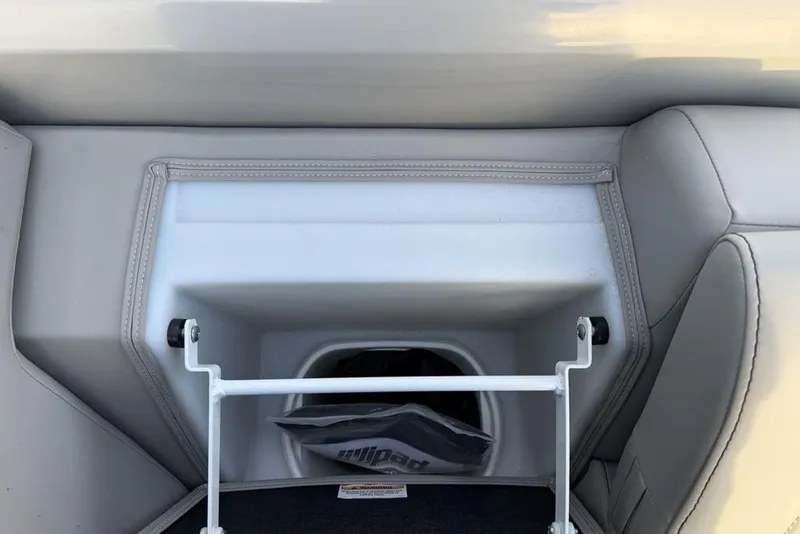 Slide: The Image of 2025 Barletta 23UC boat storage compartment with gray upholstery and white frame. - 17