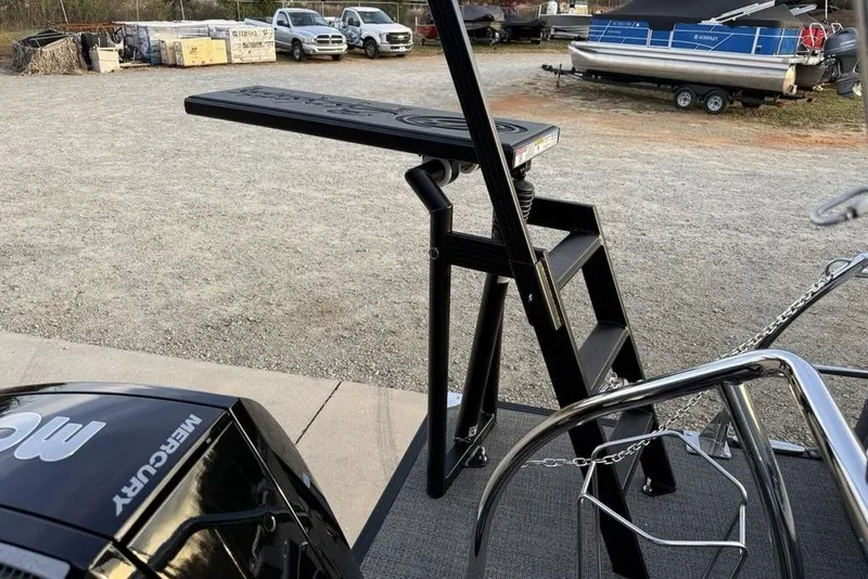 Slide: The Image of 2025 Barletta 23UC boat with Mercury engine and boarding ladder in a marina setting. - 26