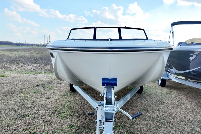 Slide: The Image of 2026 Bayliner Element M19 boat on trailer, parked on grassy field under blue sky. - 12