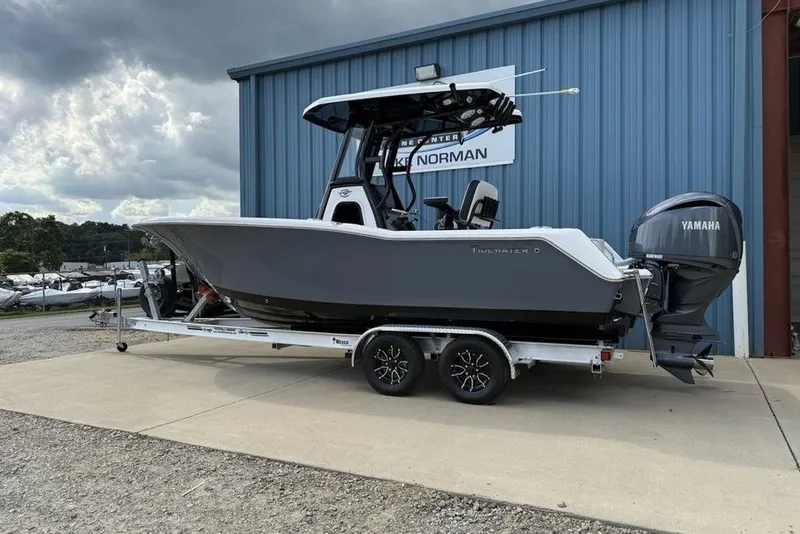 Slide: The Image of 2026 Tidewater 232 CC Adventure boat on trailer, parked outside a blue building. - 31