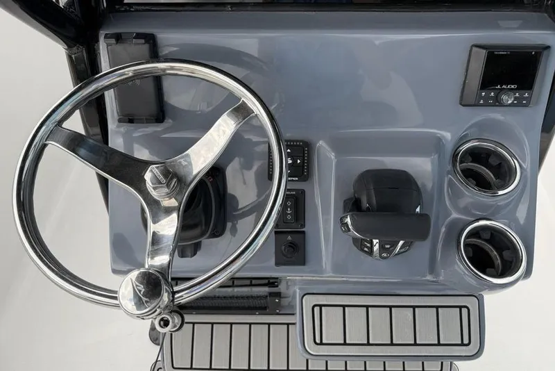 Slide: The Image of 2026 Tidewater 232 CC Adventure boat dashboard with steering wheel and controls. - 6