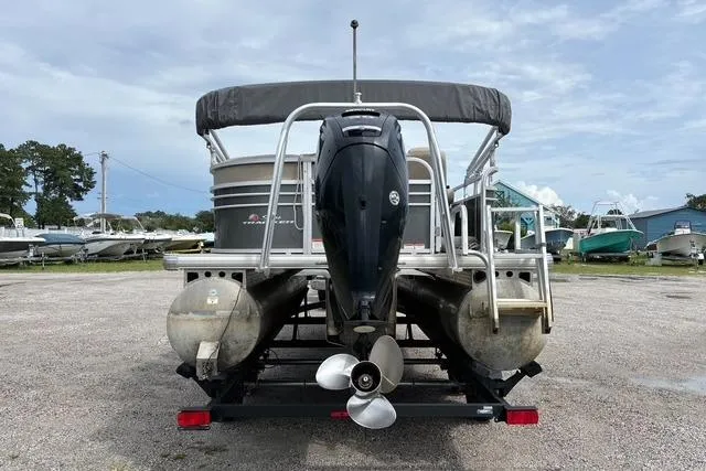 Slide: The Image of 2021 Sun Tracker Party Barge 20 DLX pontoon boat with outboard motor, parked on gravel. - 3