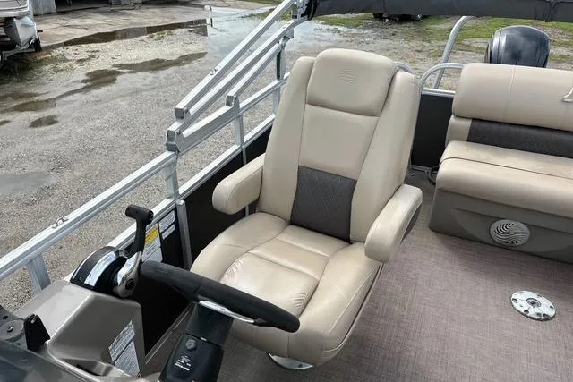 Slide: The Image of 2021 Sun Tracker Party Barge 20 DLX interior with beige captain's chair and steering console. - 9