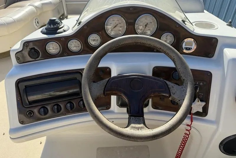 Slide: The Image of Steering console of a 2002 Godfrey AP220RS boat with gauges and controls. - 13