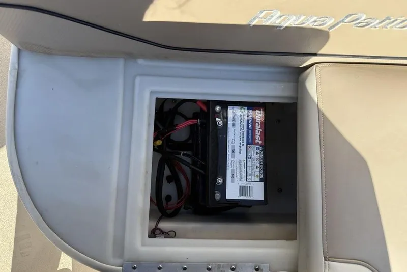 Slide: The Image of Battery compartment of a 2002 Godfrey AP220RS boat, featuring a Duralast marine battery. - 15
