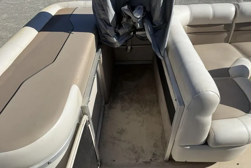 Slide: The Image of 2002 Godfrey AP220RS boat interior with beige seating and covered controls. - 23