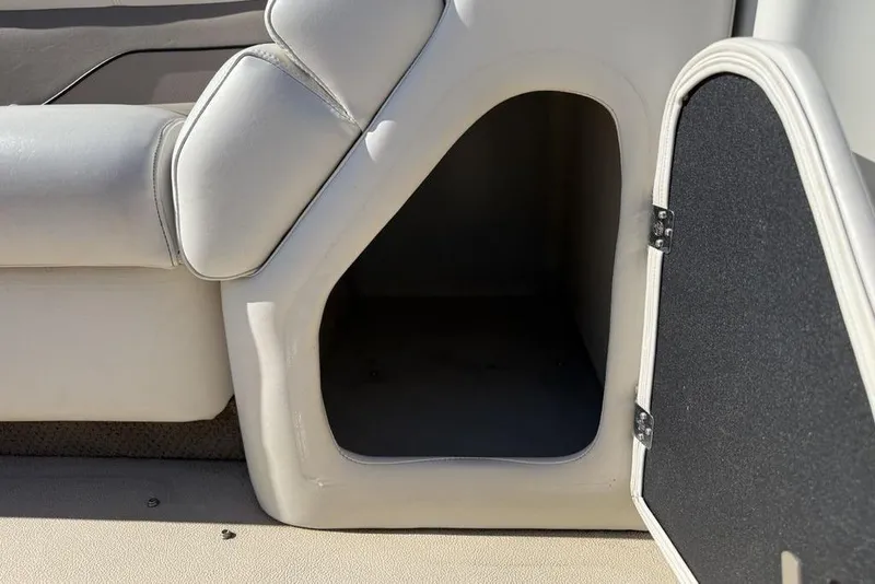 Slide: The Image of Storage compartment in a 2002 Godfrey AP220RS boat, featuring cushioned seating and open hatch. - 9