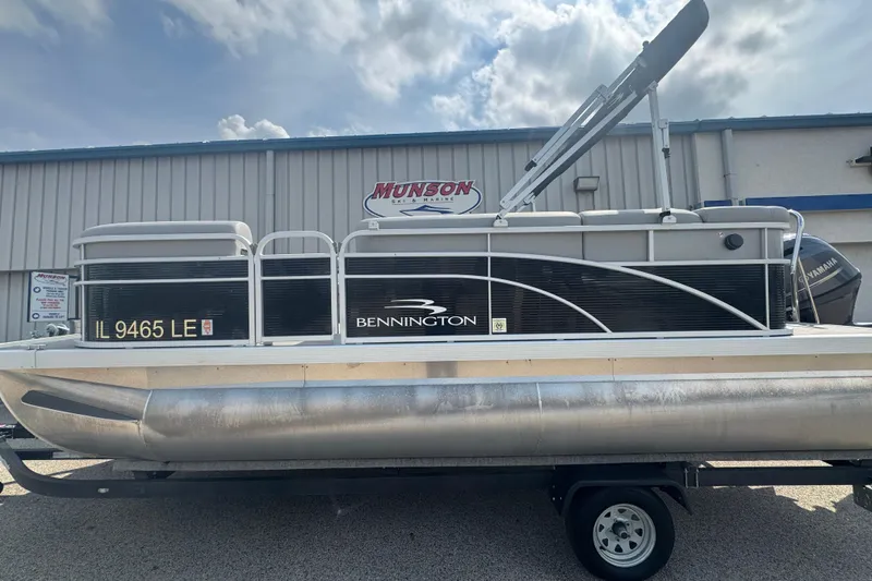Slide: The Image of 2023 Bennington 20 SL pontoon boat on trailer, parked outside Munson Marine. - 3