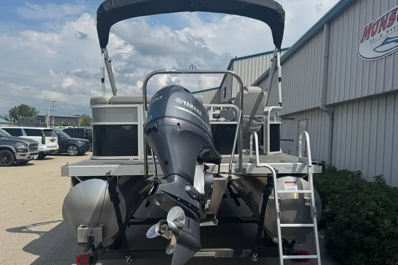 Slide: The Image of 2023 Bennington 20 SL pontoon boat with Yamaha outboard motor, parked outdoors. - 6