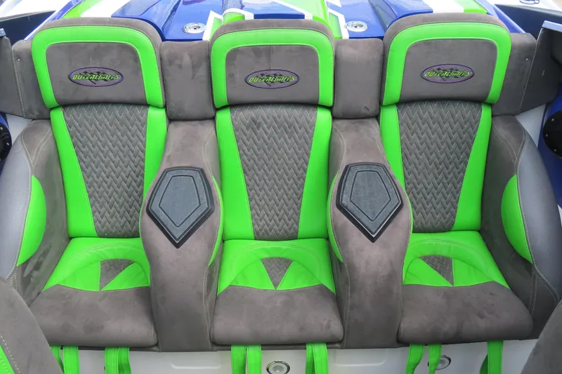 Slide: The Image of 2007 Outerlimits 44 GTX boat seats with green and gray upholstery, featuring logo details. - 17