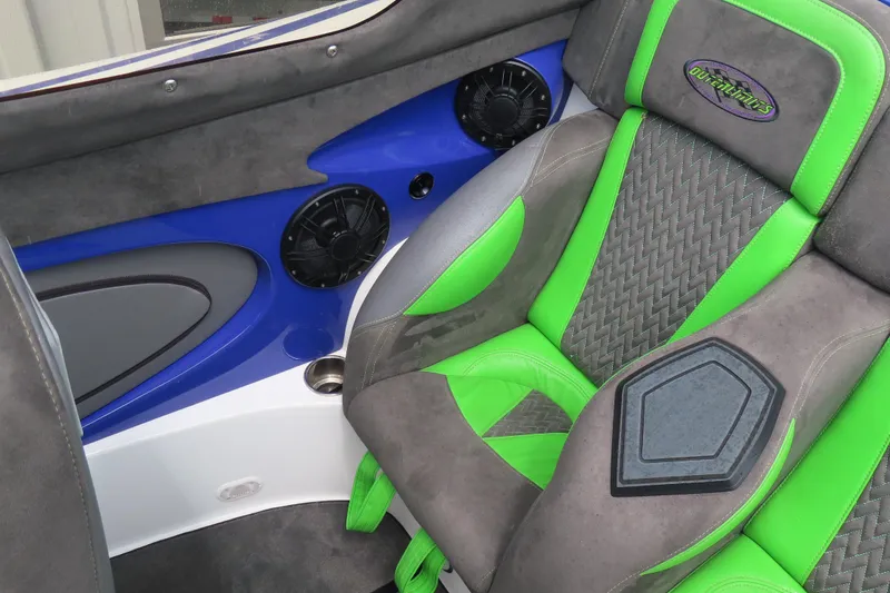 Slide: The Image of 2007 Outerlimits 44 GTX boat interior with green and gray seating, blue accents, and speaker. - 18