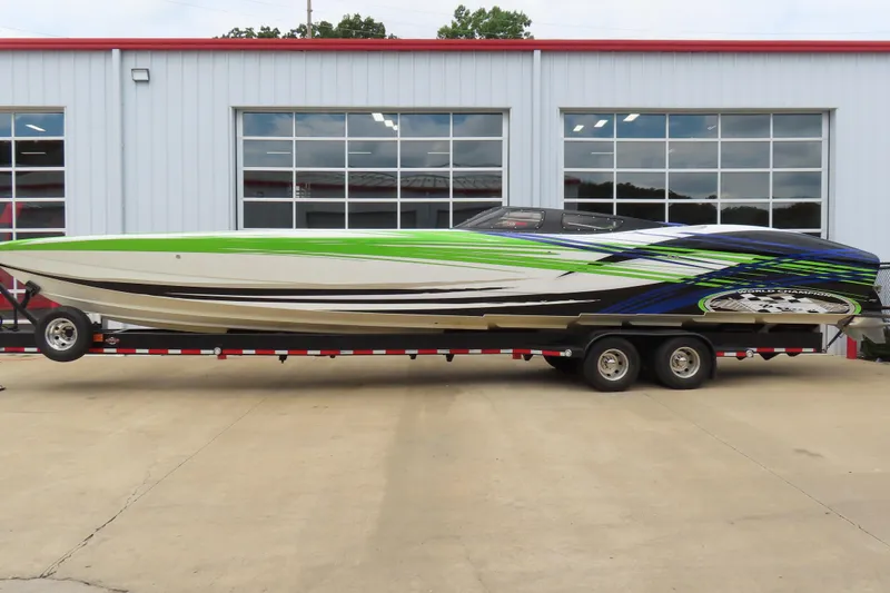 Slide: The Image of 2007 Outerlimits 44 GTX speedboat with vibrant green and blue design on trailer. - 2