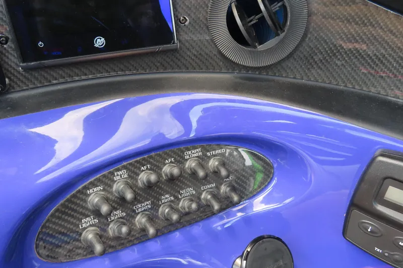 Slide: The Image of Control panel of a 2007 Outerlimits 44 GTX boat with various switches and displays. - 25