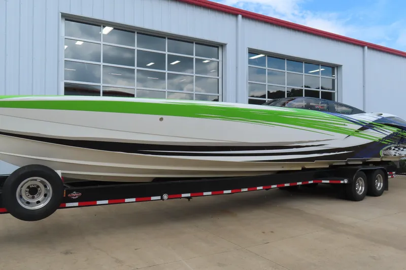 Slide: The Image of 2007 Outerlimits 44 GTX speedboat on trailer, vibrant green and white design. - 3