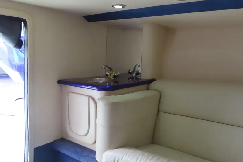 Slide: The Image of Interior of 2007 Outerlimits 44 GTX boat featuring a compact kitchenette and seating area. - 35