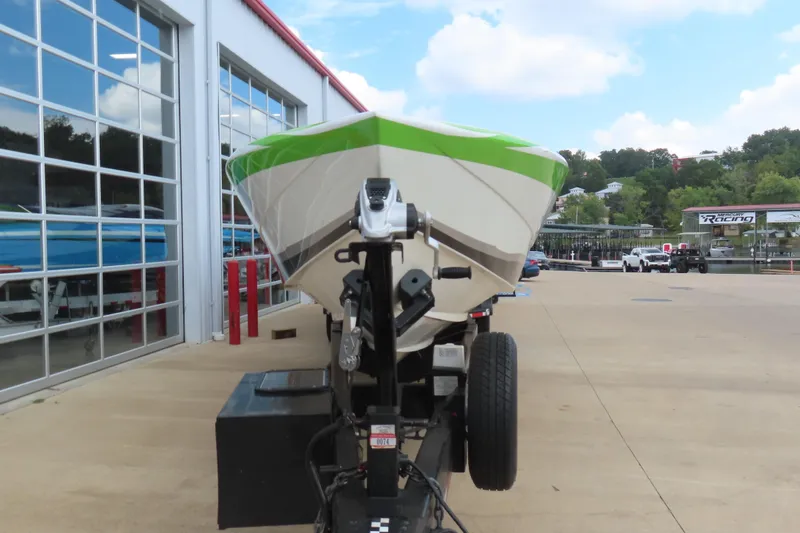 Slide: The Image of 2007 Outerlimits 44 GTX boat on trailer outside a garage, featuring a green and white hull. - 4