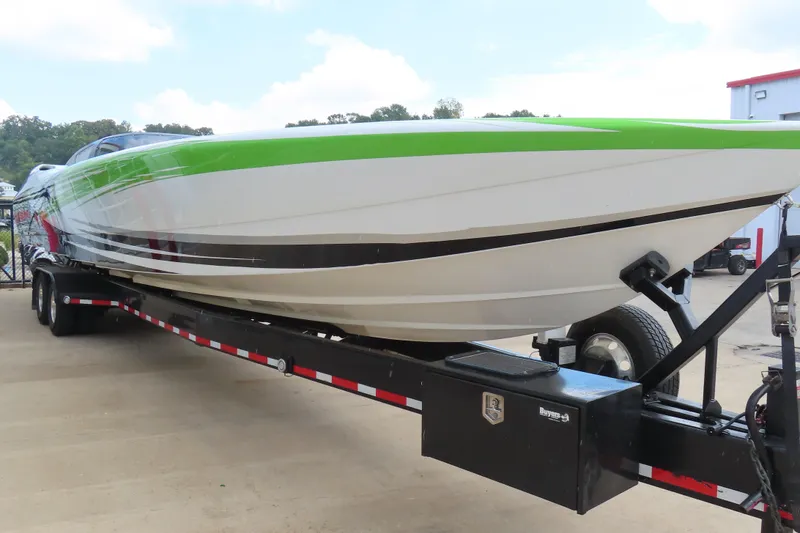 Slide: The Image of 2007 Outerlimits 44 GTX powerboat on trailer, featuring a sleek green and white design. - 5