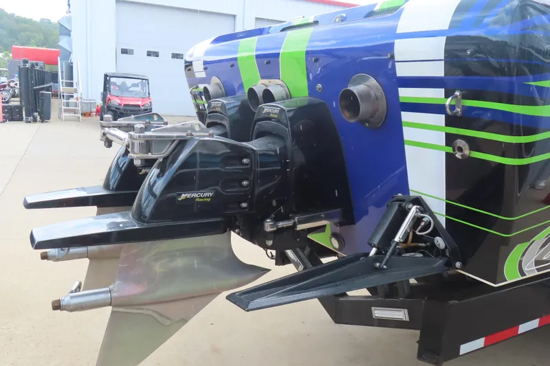 Slide: The Image of 2007 Outerlimits 44 GTX boat with Mercury Racing engines, vibrant blue and green design. - 8