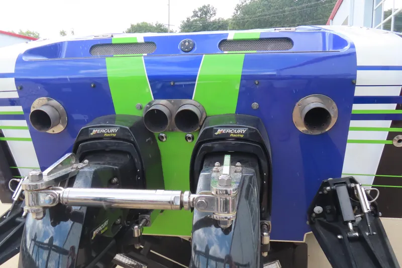 Slide: The Image of 2007 Outerlimits 44 GTX boat with Mercury Racing engines, vibrant blue and green design. - 9