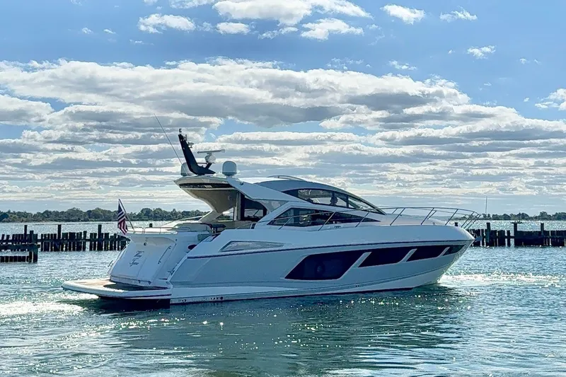 Slide: The Image of 2016 Sunseeker Predator 57 yacht cruising on a sunny day with scenic water backdrop. - 2