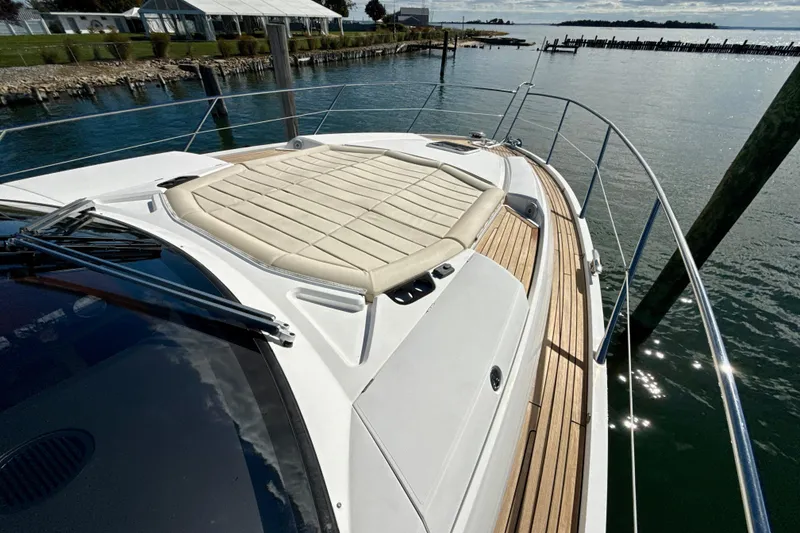 Slide: The Image of 2016 Sunseeker Predator 57 yacht with sunpad, docked by calm waters. - 24