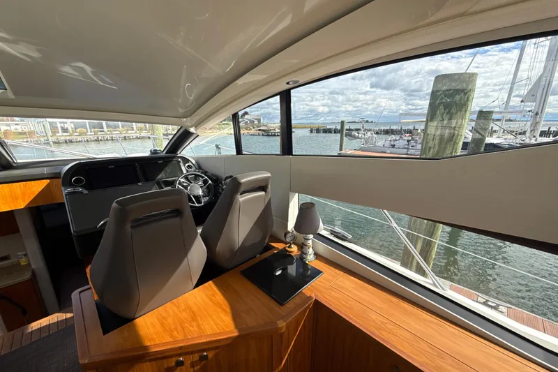 Slide: The Image of Interior view of 2016 Sunseeker Predator 57 yacht helm with marina backdrop. - 43