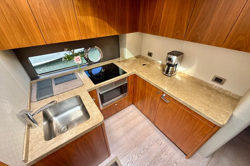 Slide: The Image of Luxurious 2016 Sunseeker Predator 57 yacht kitchen with modern appliances and elegant wood cabinetry. - 51