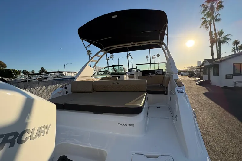 Slide: The Image of 2026 Sea Ray SDX 230 Outboard boat with Mercury engine, docked at sunset. - 2