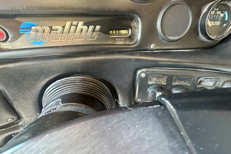 Slide: The Image of Dashboard of a 1998 Malibu Response boat with gauges and controls. - 11