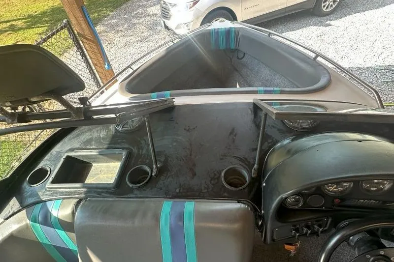 Slide: The Image of 1998 Malibu Response boat interior with dashboard, seating, and open compartments. - 12