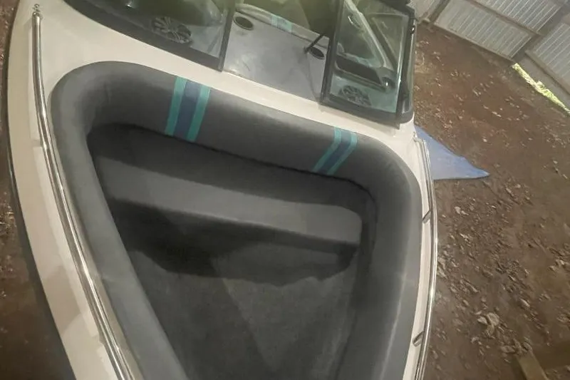 Slide: The Image of 1998 Malibu Response boat interior with gray seating and teal accents in a storage area. - 5