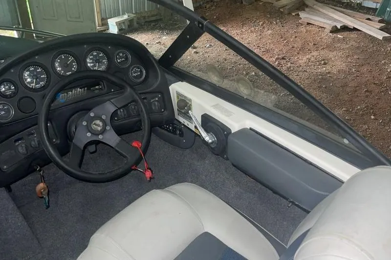 Slide: The Image of 1998 Malibu Response boat interior with steering wheel and dashboard gauges. - 7