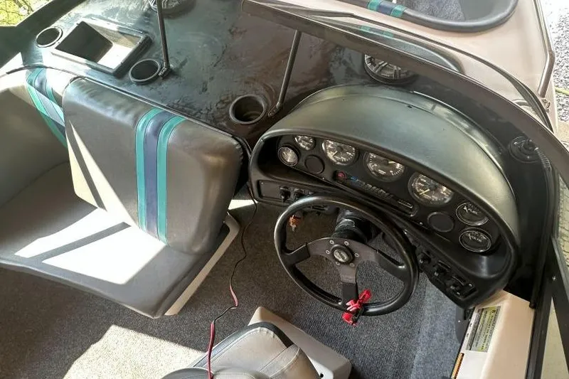 Slide: The Image of 1998 Malibu Response boat interior with steering wheel, dashboard, and seating. - 8