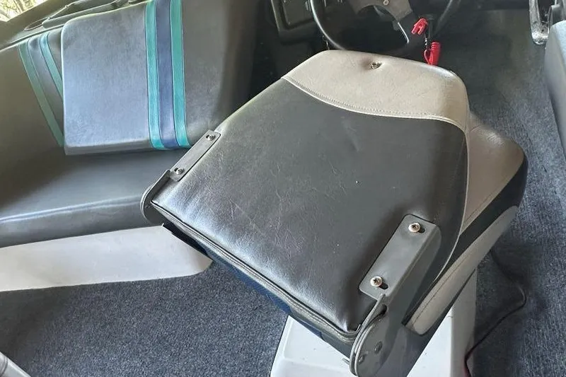 Slide: The Image of Interior of a 1998 Malibu Response boat with black and gray seating. - 9