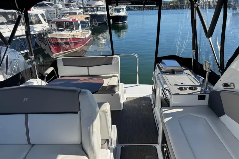 Slide: The Image of 2020 Four Winns Vista 275 interior with seating and kitchenette, docked at marina. - 12