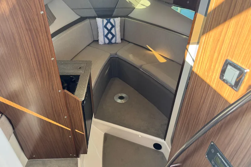 Slide: The Image of 2020 Four Winns Vista 275 cabin interior with seating and wood paneling. - 13