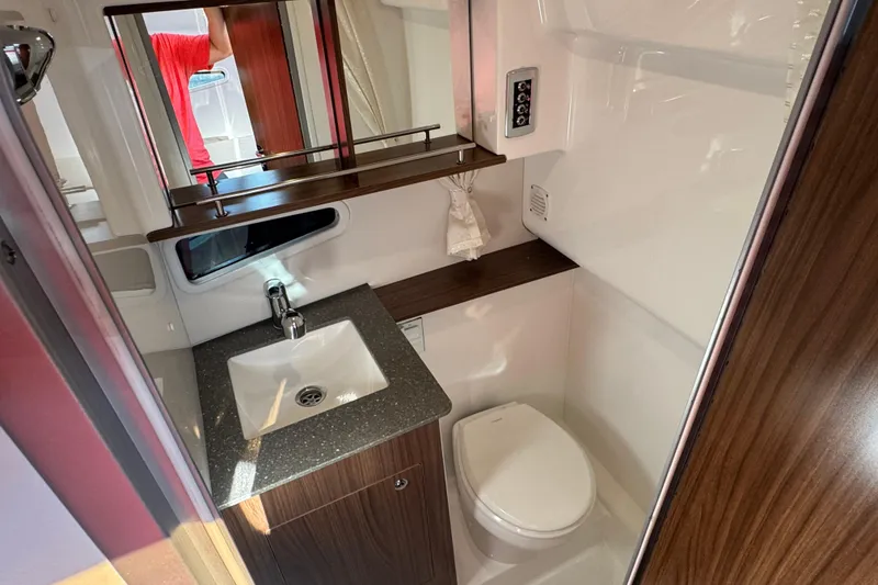 Slide: The Image of 2020 Four Winns Vista 275 bathroom with sink, toilet, and mirror. - 16