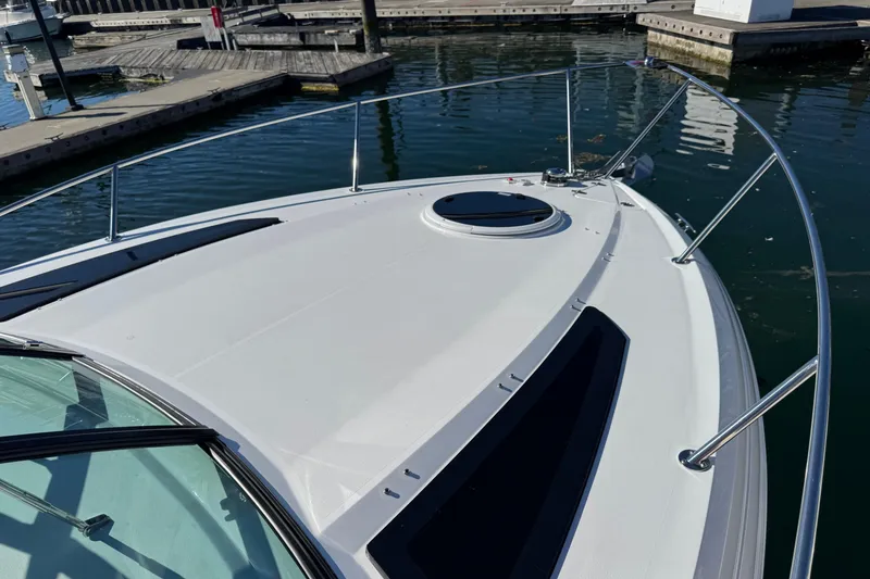 Slide: The Image of 2020 Four Winns Vista 275 boat docked at marina, showcasing sleek deck design. - 22