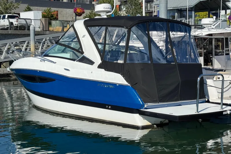 Slide: The Image of 2020 Four Winns Vista 275 boat docked in marina, featuring blue and white exterior. - 3