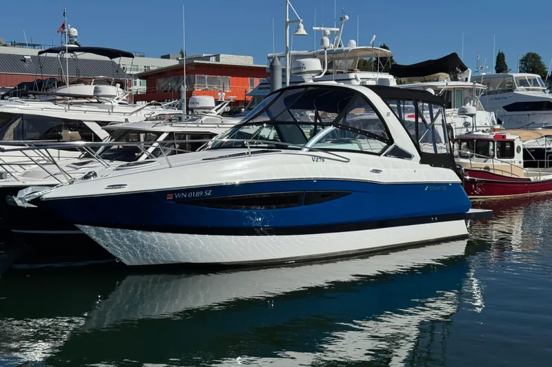 Slide: The Image of 2020 Four Winns Vista 275 boat docked in a marina, surrounded by other vessels. - 5