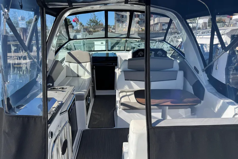 Slide: The Image of 2020 Four Winns Vista 275 boat interior with seating and helm, docked at marina. - 6