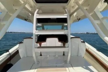 Slide: The Image of 2019 Scout 420 LXF boat interior with seating, ocean view, and clear sky. - 11