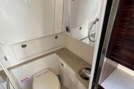 Slide: The Image of 2019 Scout 420 LXF boat bathroom with toilet, sink, and storage cabinets. - 19