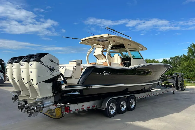 Slide: The Image of 2019 Scout 420 LXF boat on trailer with four powerful outboard engines. - 2
