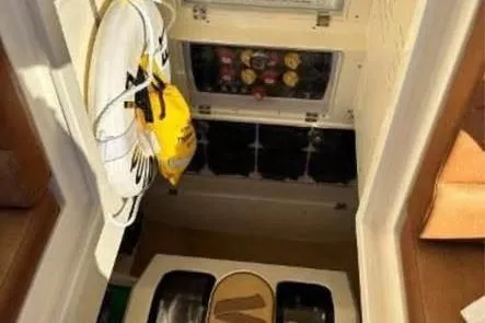 Slide: The Image of Interior view of 2019 Scout 420 LXF boat with life jackets and storage compartments. - 24