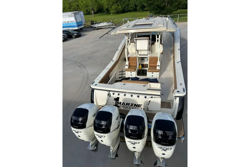 Slide: The Image of 2019 Scout 420 LXF boat with four powerful outboard engines, docked on concrete. - 27