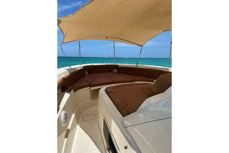 Slide: The Image of Luxurious 2019 Scout 420 LXF boat interior with sunshade, overlooking turquoise ocean waters. - 28